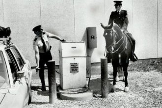 Watching Const. Paul Dewsnap gas up his patrol car, Const. James Barger and his mare, Joan, prove that horses are more fuel-efficient than autos.